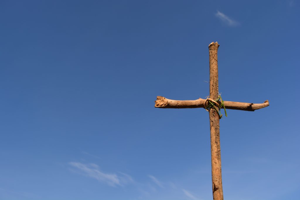 Cruz de madera bajo un cielo azul